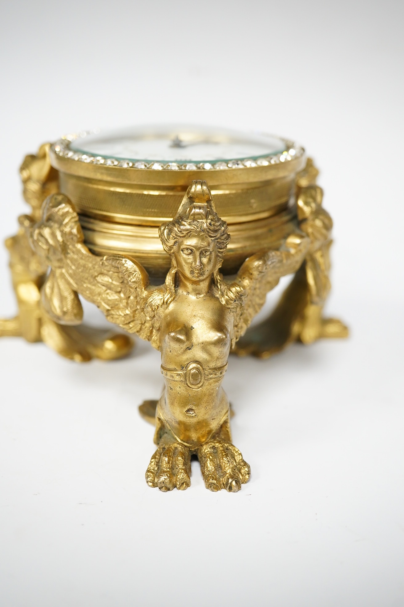 A 19th century French ormolu table timepiece decorated with paste jewelling edged dial and three classical figures, widest point 15cm. Condition - good, not been checked as working